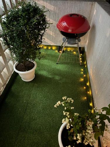 a balcony with two potted plants and a stool with lights at ORY luxury garden in Abidjan