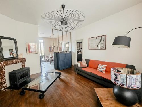 un salon avec un canapé et une cheminée dans l'établissement La Belle Maison, centre ville, 3 chambres et jardin, à Reims