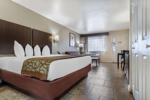 コーパスクリスティにあるBest Western Padre Islandの大きなベッドと机があるホテルの部屋