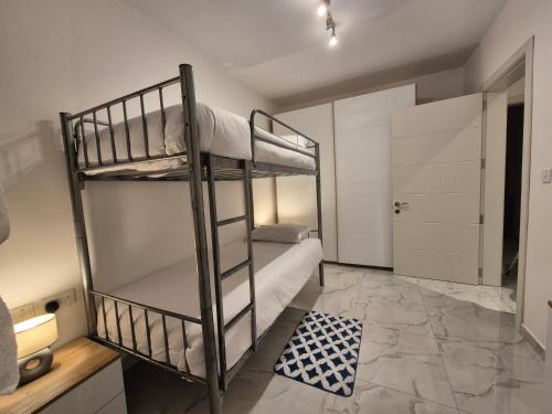 a room with two bunk beds and a bathroom at 3BR Family Stay Near Valletta in Hamrun