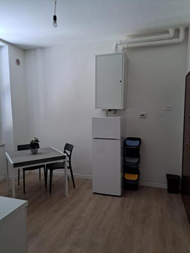a kitchen with a table and a white refrigerator at San Francesco Home in Terni