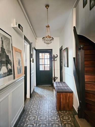 un couloir avec une porte noire et un banc dans l'établissement La Belle Maison, centre ville, 3 chambres et jardin, à Reims