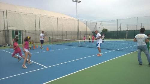 a group of people playing tennis on a tennis court at Il Poggio Agrisport in Poirino