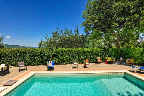 a swimming pool with chairs and a table at Acquanera 6&2 by Marche Holiday Villas in Piobbico