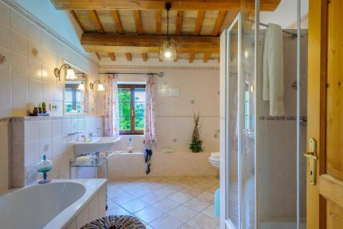 a bathroom with a tub and a sink and a shower at La Girolima 6&2 by Marche Holiday Villas in Mondavio