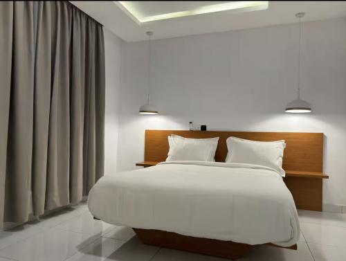 a bedroom with a large bed with white sheets and pillows at ORY luxury garden in Abidjan
