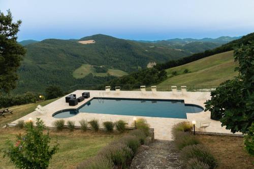 a swimming pool on a hill with mountains in the background at Ca Quattrocchi 10&3 by Marche Holiday Villas in Apecchio