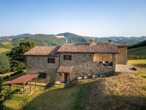 an old stone house with a gazebo in front at Ca Quattrocchi 10&3 by Marche Holiday Villas in Apecchio