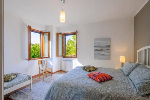 une chambre avec un lit, une chaise et des fenêtres dans l'établissement Casa Felicita 8 by Marche Holiday Villas, à Macchie