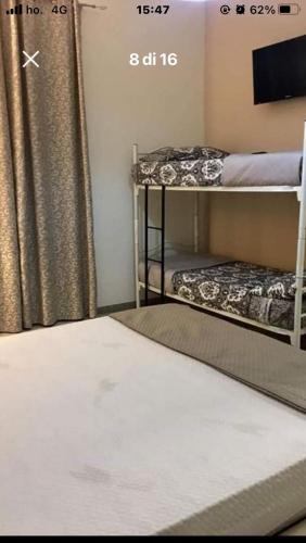 Una habitación con dos literas y un televisor. en Casa Lella, en Policoro