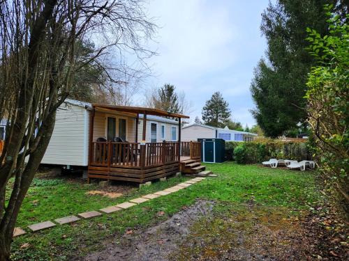 a tiny house with a porch and a deck at Mobile home 6P XL Climatisation TV WIFI parcelle XXL au calme in Ivry-la-Bataille