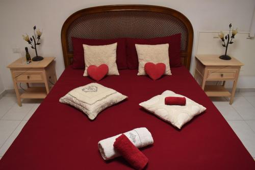 a bed with three pillows and two hearts on it at Al Borgo - Tenuta Borsari in Frascati