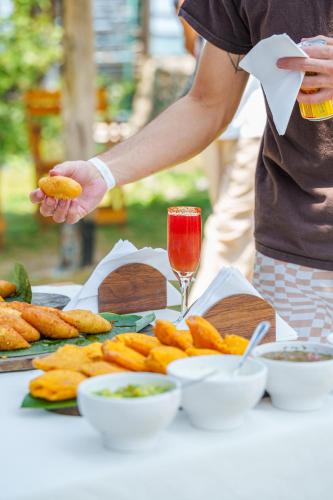 a person holding a piece of food on a table at Vista Mare Beach House in Tierra Bomba