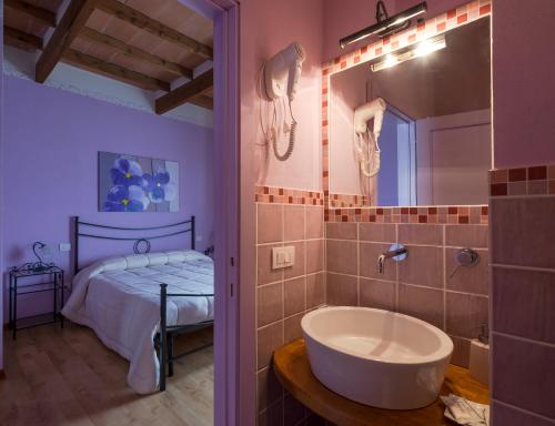 un bagno con vasca e una camera con letto di Giannetti Bed & Breakfast a Poggio alle Mura