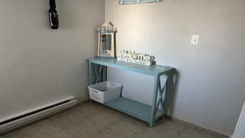 a blue console table in a corner of a room at Pavloski in Beach Haven