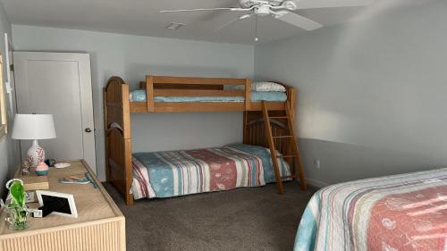a bedroom with two bunk beds and a table at Pavloski in Beach Haven