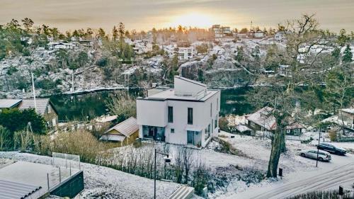 a white house in a snow covered city at Exklusiv villa med sjöutsikt och egen brygga in Nacka