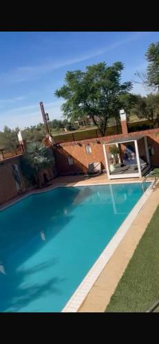 a large blue swimming pool in front of a house at Amlkis golf royal in Marrakech