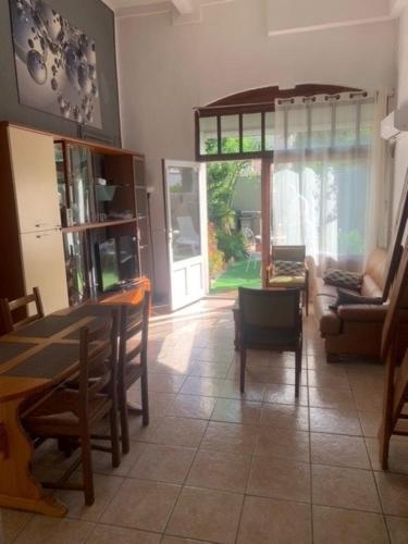 - un salon avec une table, des chaises et une porte dans l'établissement Chez Anna, maison de ville, à Frontignan