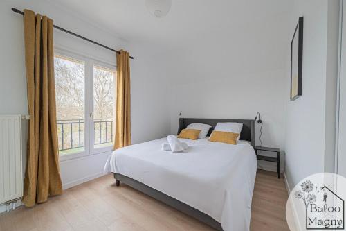 ein Schlafzimmer mit einem Bett und einem großen Fenster in der Unterkunft Hercule - Séjour héroïque à Disneyland Paris in Magny-le-Hongre