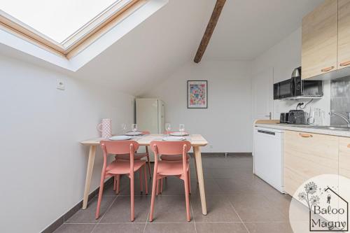 une cuisine avec une table et des chaises dans une pièce dans l'établissement Hercule - Séjour héroïque à Disneyland Paris, à Magny-le-Hongre