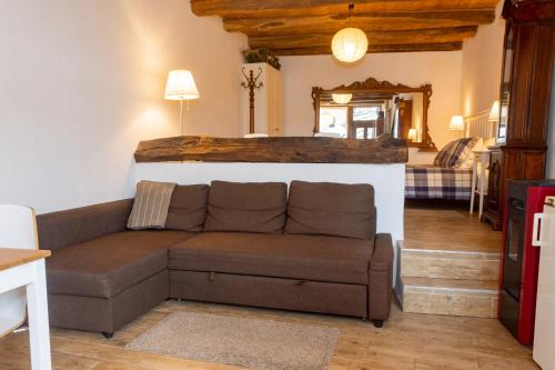 salon z brązową kanapą w pokoju w obiekcie Medieval Hamlet Malpertus w mieście Bobbio Pellice