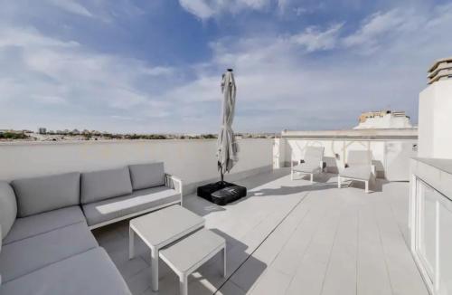 a patio with a couch and chairs on a roof at Luxury Penthouse - Rooftop Pool - 100m to the Sea in Torrevieja