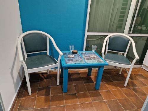 two chairs and a table with a blue table at Gwada paradise, marina du gosier in Le Gosier