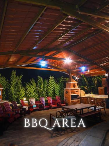 a pavilion with chairs and a table and a grill at The River House - Upscale Lodge in Puerto Quito