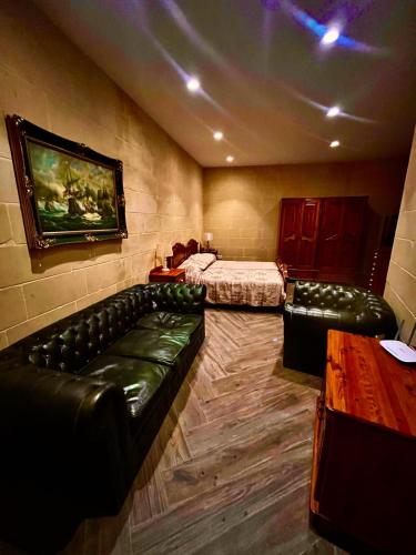 a room with two beds and leather couches in a room at Charming 1-Bedroom in Rabat by SF Homes in Ħal-Bajjada