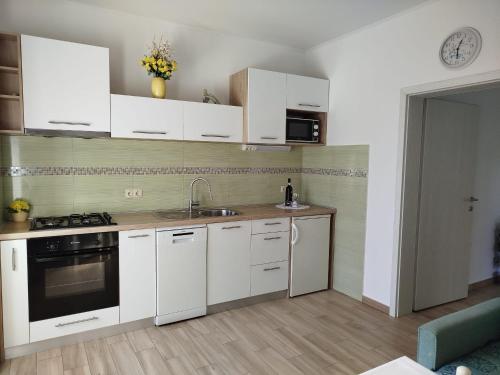 a kitchen with white cabinets and a sink at Cute apartment Arba in Rab