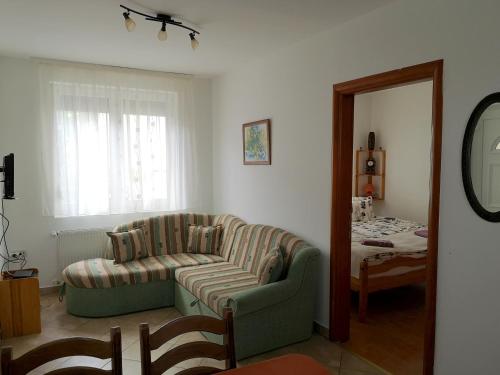a living room with a couch and a mirror at Blanka Vendégház in Abádszalók