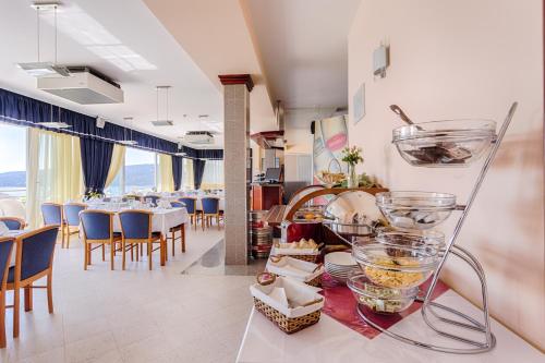 a restaurant with tables and chairs in a room at Hotel Viktorija in Seget Vranjica