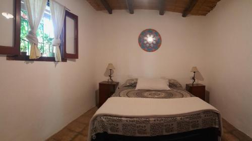 a bedroom with a bed and a clock on the wall at Casa Prana Estudio de Yoga in Cafayate