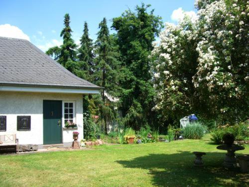 un patio con una casa blanca y árboles y un patio sidx sidx sidx sidx en Bastgen Bed & Breakfast, en Wittlich