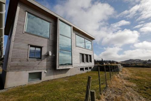 a house with glass windows on the side of it at Vestre Karmøyveg 845 in Karmøy
