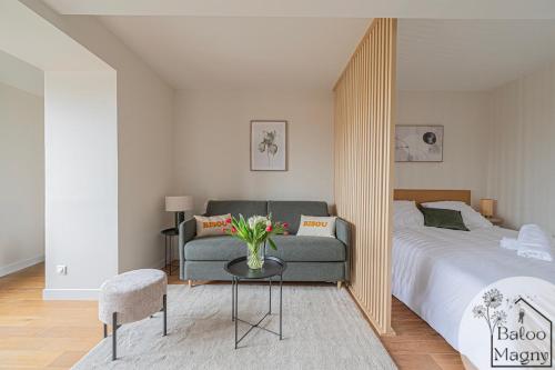 a bedroom with a bed and a couch and a table at Le Refuge de Bagheera à Disneyland in Magny-le-Hongre