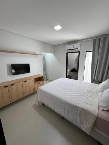 a bedroom with a bed and a flat screen tv at Casa Villages Piranhas in Piranhas