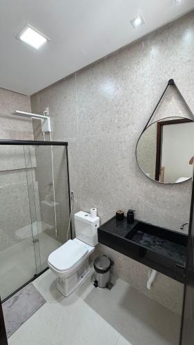 a bathroom with a toilet and a mirror at Casa Villages Piranhas in Piranhas