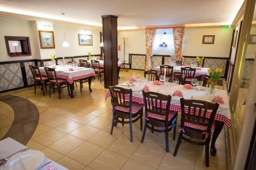 a dining room with tables and chairs with flowers on them at Hotel & Restauracja Gniecki in Hrubieszów