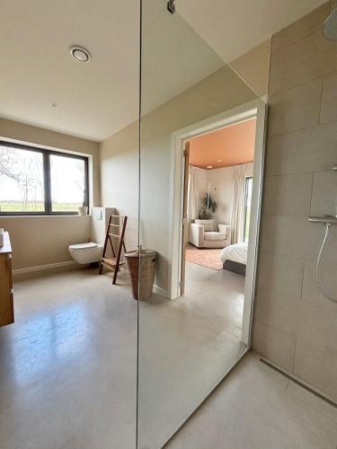 a bathroom with a glass shower and a bedroom at Gezellig gezinsverblijf op het platteland in Jabbeke