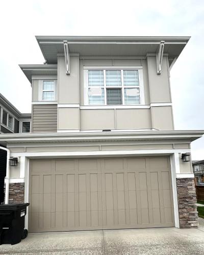 a house with a garage door in front of it at Private Very Spacious 2 bed 1-Bedroom basement Suite SW Calgary in Calgary