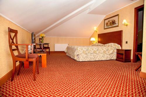 a hotel room with a bed and a desk at Optima Collection Kamianets-Podilskyi in Kamianets-Podilskyi