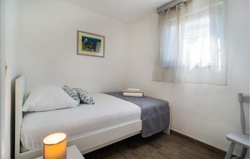 a small bedroom with a white bed and a window at Gorgeous Home In Selca in Selca