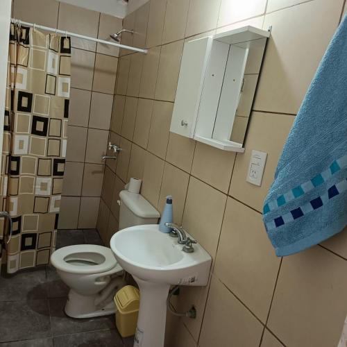 a bathroom with a sink and a toilet and a mirror at Hospedaje "Crisbel" en Las Catitas in Las Catitas