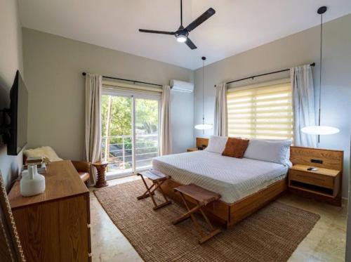 una camera da letto con un letto e una grande finestra di Modern 6 Br Villa With Hot Tub a Sosúa