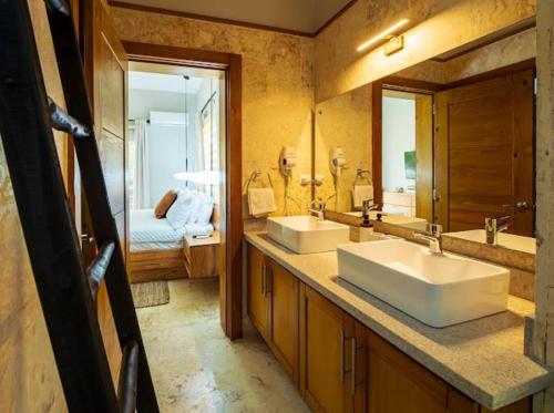 un bagno con due lavandini e un grande specchio di Modern 6 Br Villa With Hot Tub a Sosúa