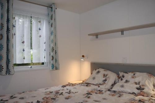 a bedroom with a bed and a window at Mobile home 6P XL Climatisation TV WIFI parcelle XXL au calme in Ivry-la-Bataille