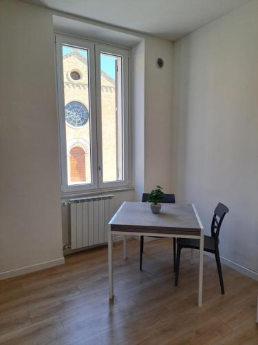 a table and a chair in a room with a window at San Francesco Home in Terni