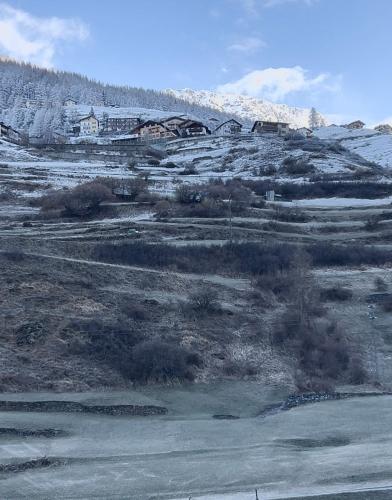 a snow covered hill with houses on top of it at La Casetta Dei Sognatori in Valfurva